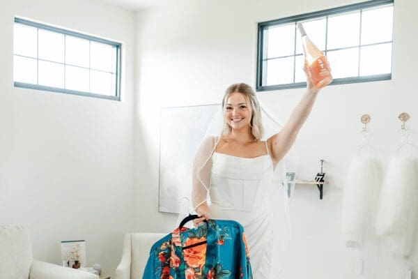 The bride to be raising a bottle of champaign signaling that she found her wedding dress
