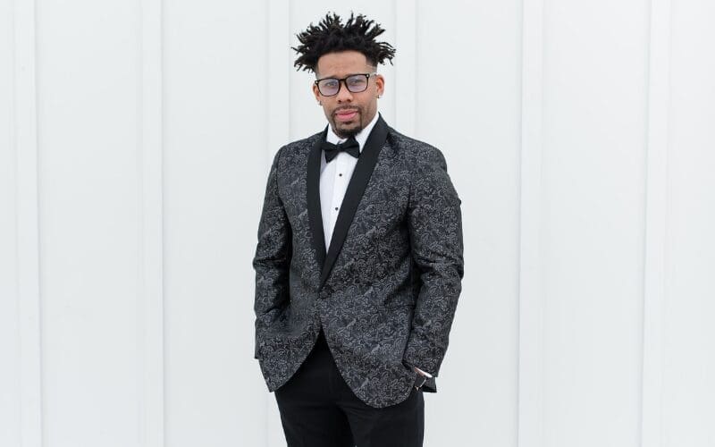 Groom wearing a patterned black tuxedo jacket with satin lapels