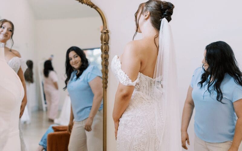 Bride viewing the back of her wedding dress with bridal stylist