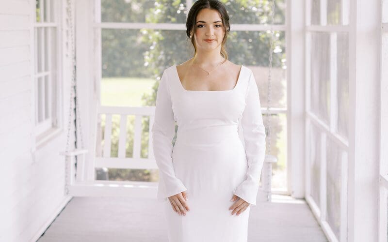 Bride wearing a fitted long-sleeve wedding dress with a square neckline