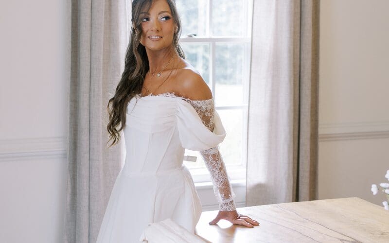 Bride wearing an off-the-shoulder wedding dress with lace sleeves