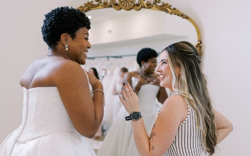 Bride and bridal stylist smiling together during a wedding dress appointment