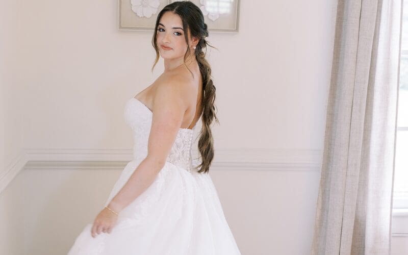 Bride posing in a strapless wedding dress with a full skirt